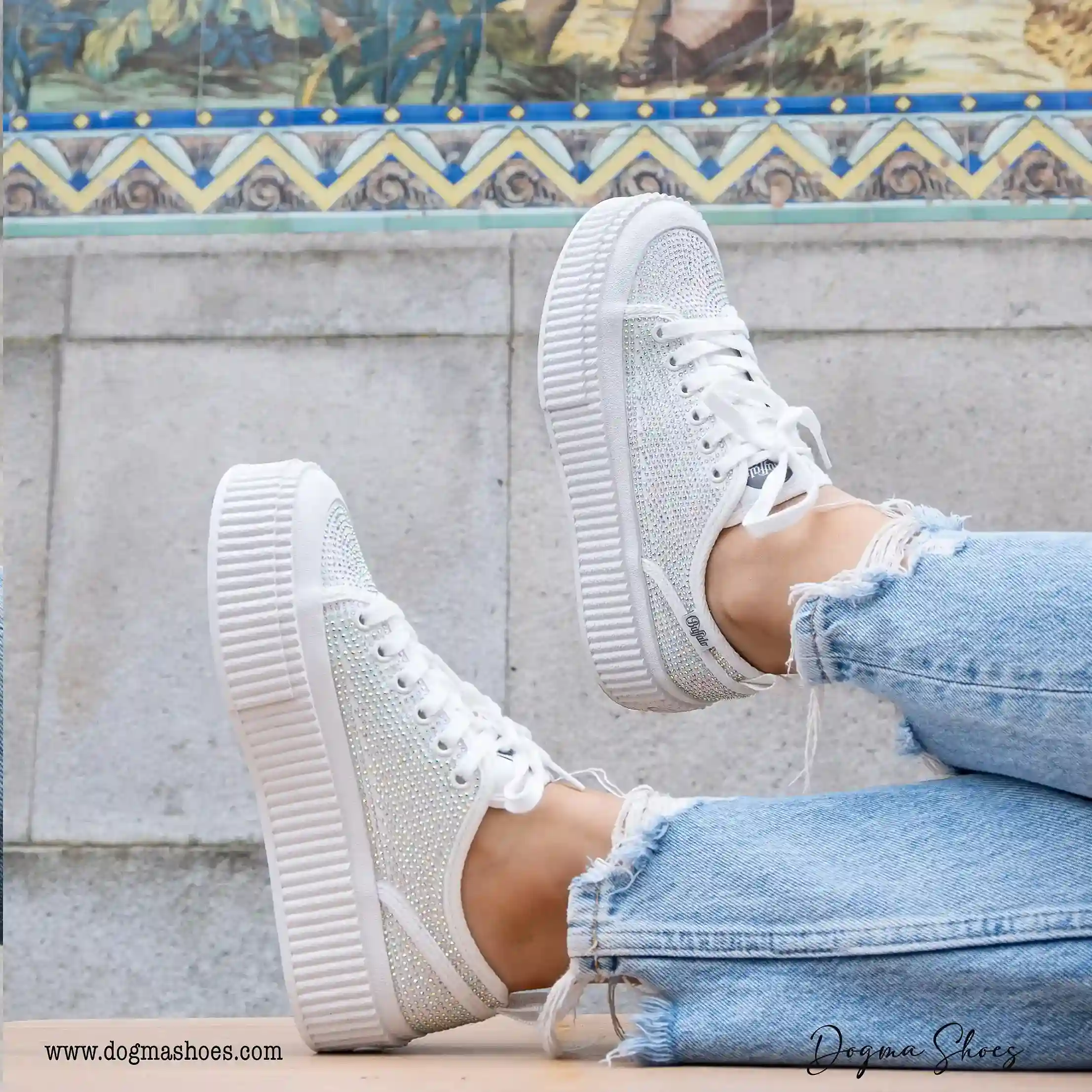 mulher com pés em cima da mesa, calçando umas sapatilhas da marca Buffalo