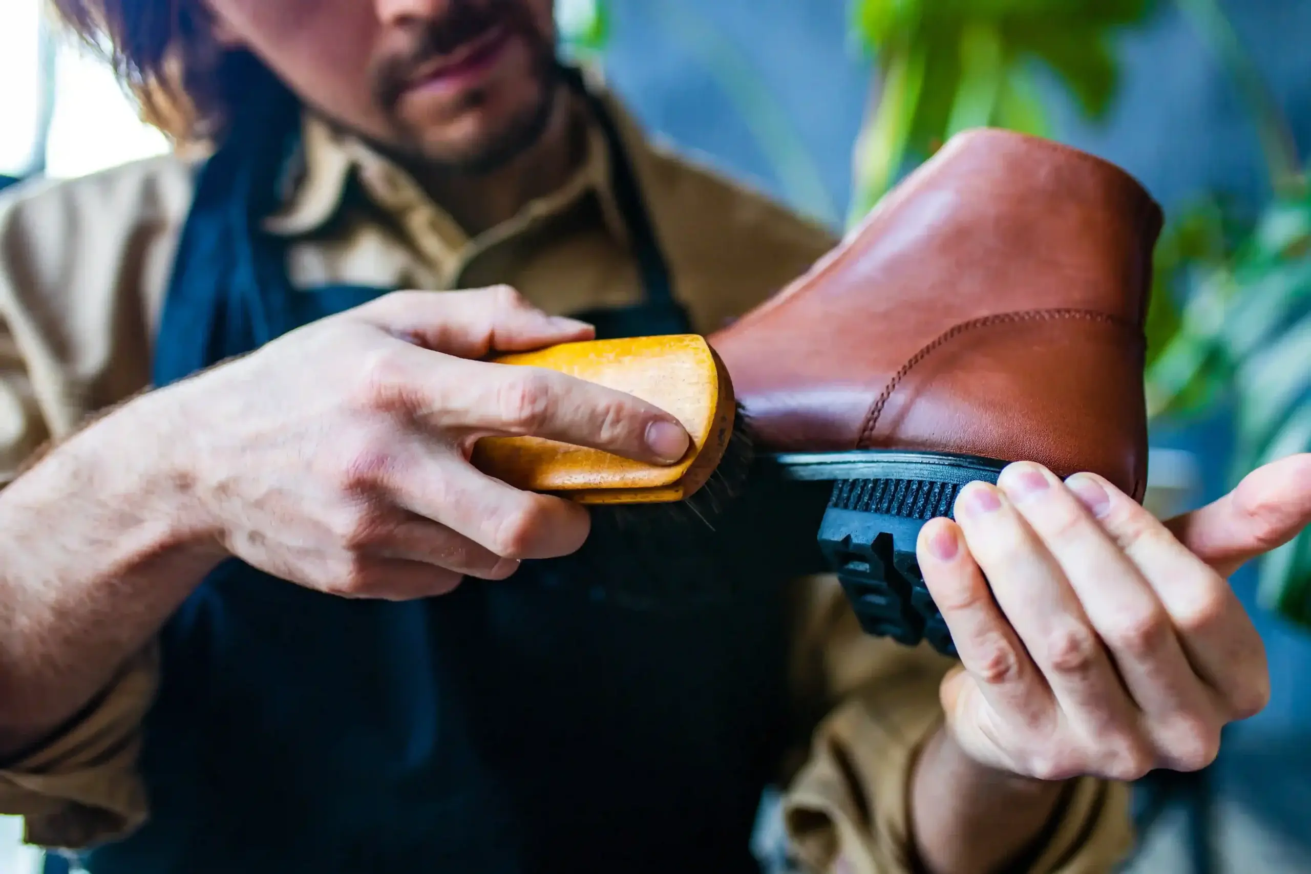 sapateiro habilidoso e limpar sapatos de couro na oficina